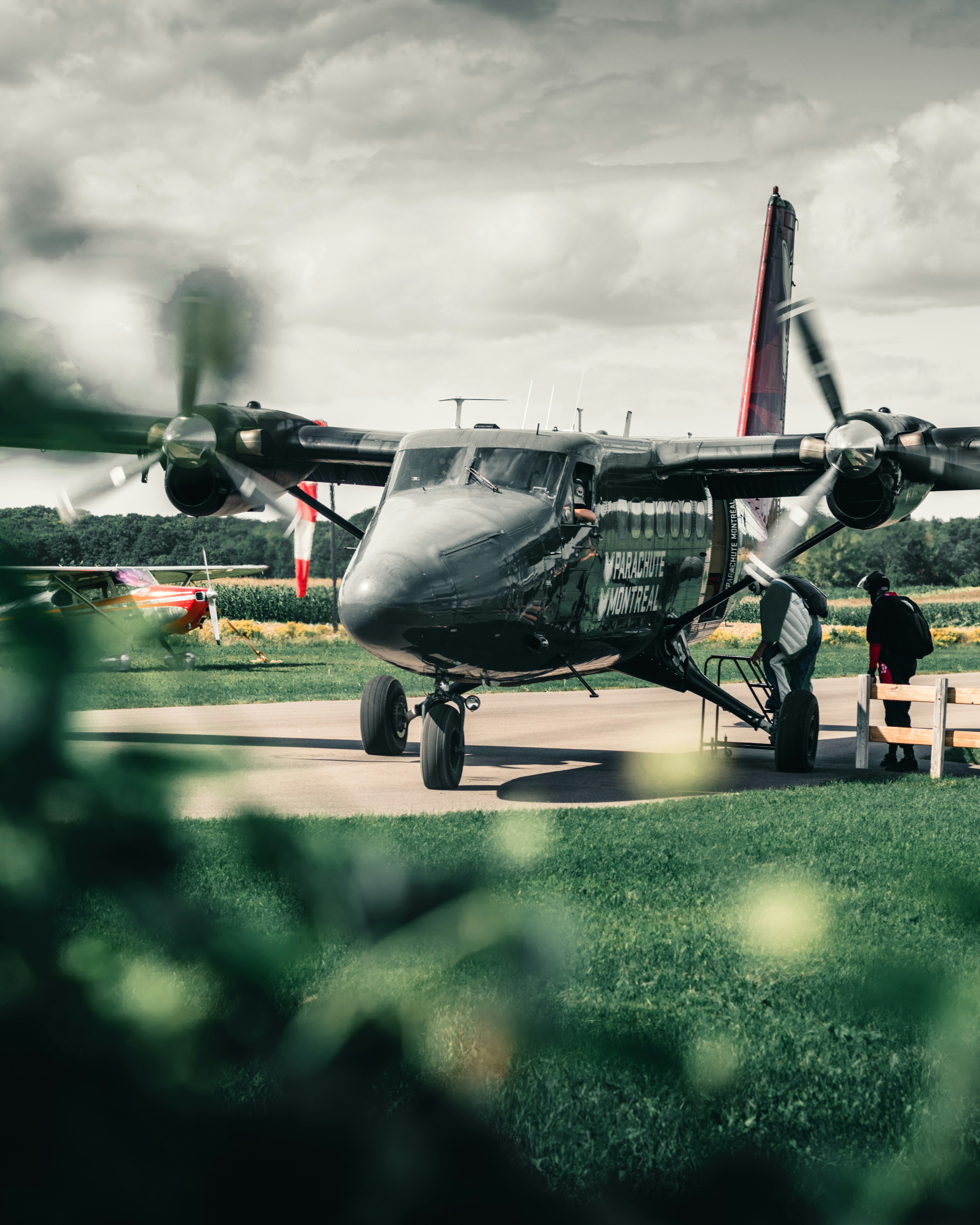 black and red jet plane on green grass field during daytime